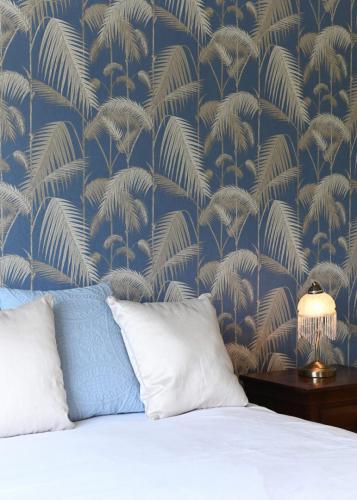 Blue bedroom with feature palm wallpaper