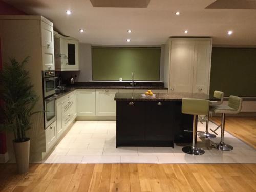Kitchen redesign- black kitchen island, green roller blind