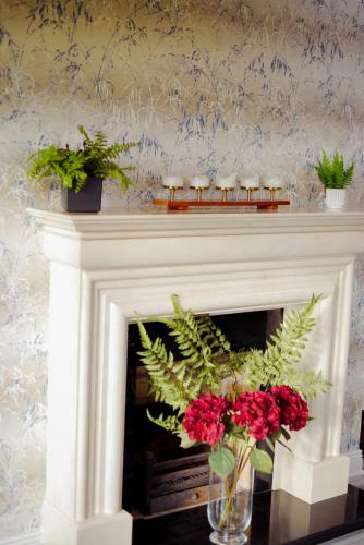Fireplace with harlequin wallpaper above