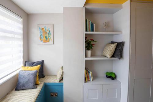 Home office design with built in window seat  units, filter blinds, grey, yellow and blue scheme